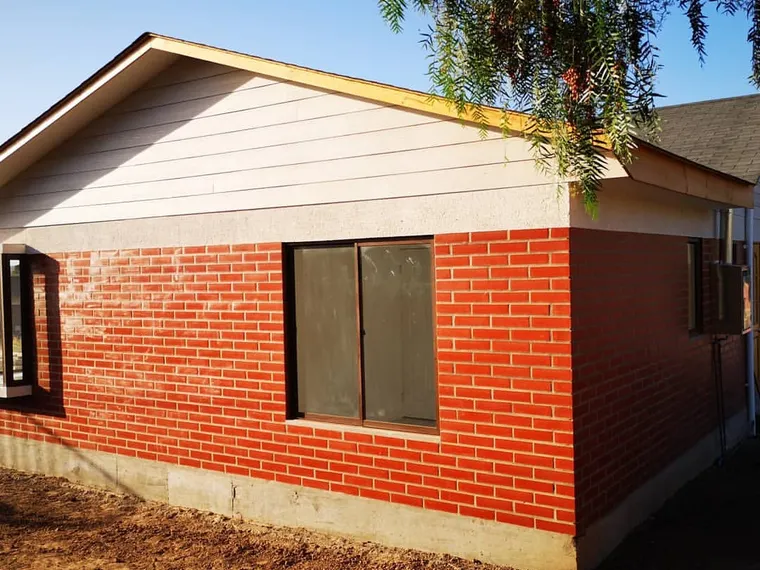Casa de ladrillo a la vista recién construida, con luz de atardecer